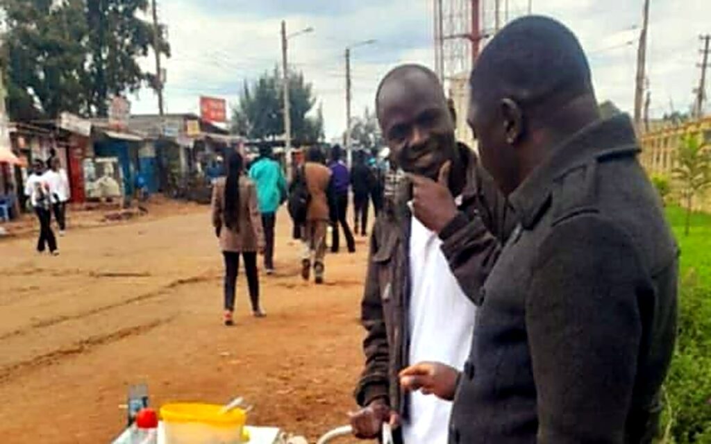 Foundation team members visiting a young entrepreneur at his roadside food cart.
