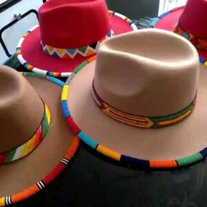 Wide-brimmed felt hats in red and camel, each with a colourful Maasai beaded band around the crown and beadwork wrapped around the edge of the brim.
