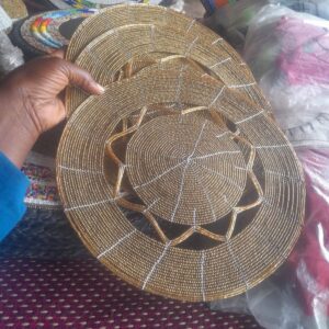 Round table mats made entirely of gold beads, each with an open star-shaped cut-out between the centre and the outer ring.