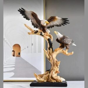 A hand-painted sculpture of two bald eagles on a carved wood-effect tree, one landing with wings spread and one perched below, on a black base.
