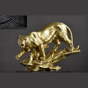 A gold-finish sculpture of a prowling tiger with carved stripes, stepping down over a textured rock base.