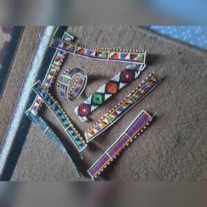 An assortment of flat Maasai beaded wristbands and a cuff bracelet in bold red, blue, orange, green, black and white patterns, including a white band with a row of coloured diamonds.