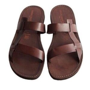 Design 1: a pair of brown leather men's slide sandals with two wide crossover straps and stitched soles.