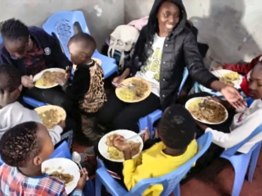 Children sharing a hot meal together at a Foundation feeding session.