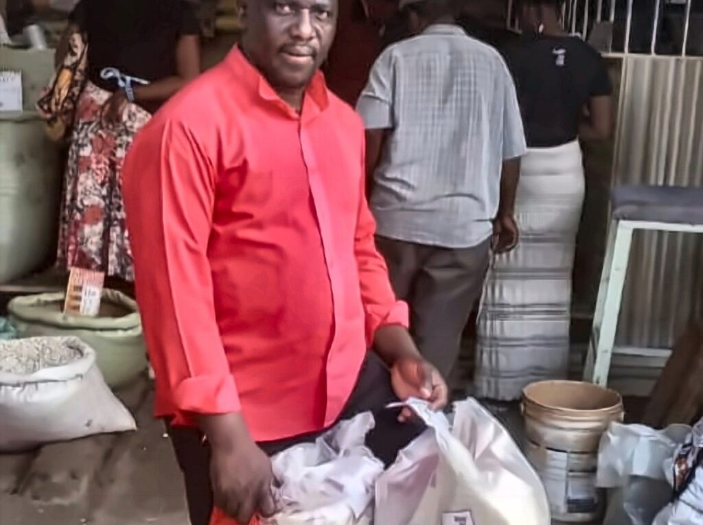 A Foundation representative collecting sacks of food staples from a wholesaler.